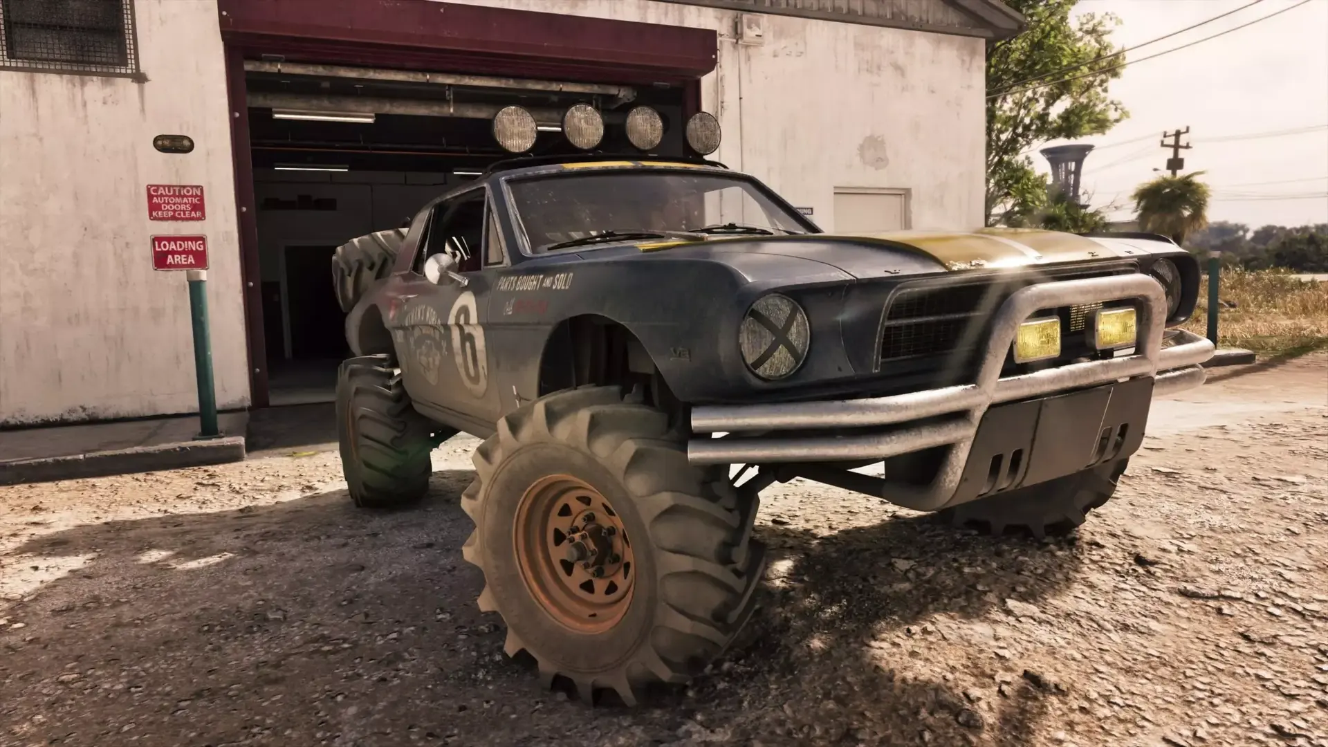 A mud-covered off-road '67 Vapid Dominator Buggy with roof lights in front of an open garage bay
