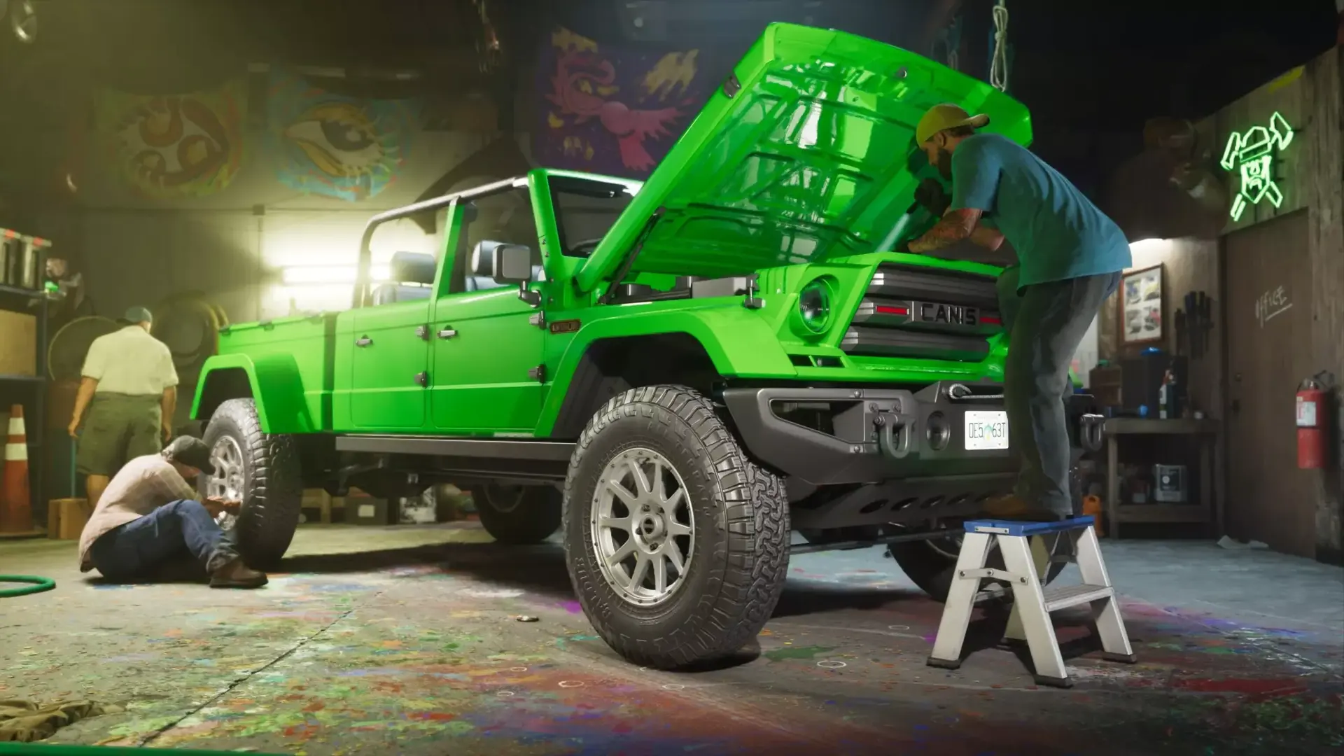 Mechanics working on a bright green off-road truck with its hood up inside a garage