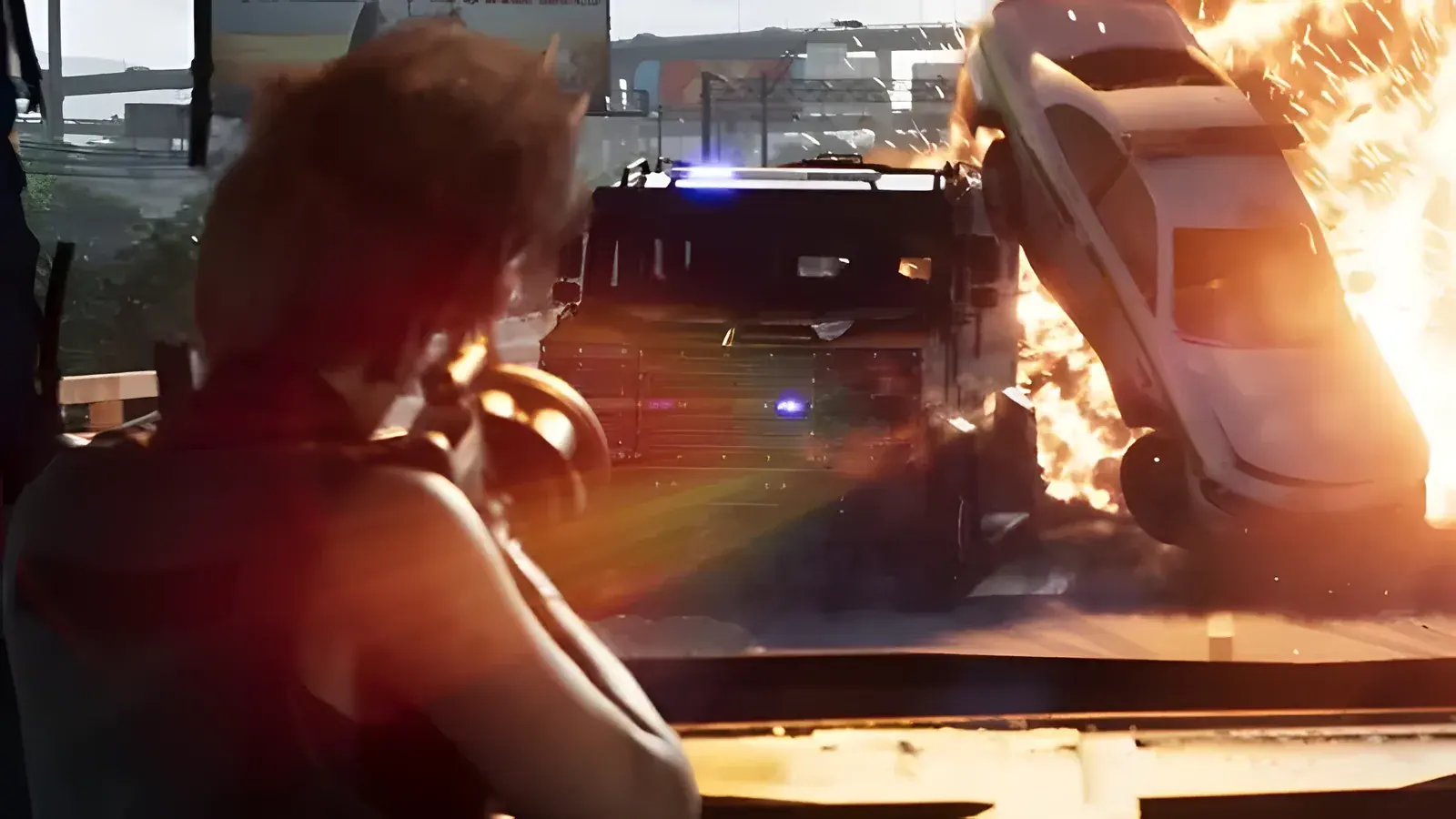 Shrewsbury Grenade Launcher in GTA 6, basata sull’arma reale Milkor MGL. Donna che punta un’arma verso un furgone blindato e un’auto in fiamme in piena esplosione, fotogramma del secondo trailer ufficiale di GTA 6