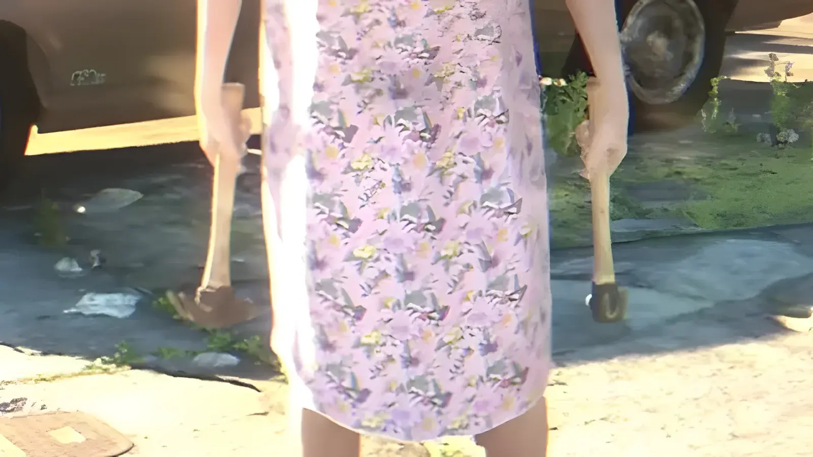 Hammer in GTA 6. Persona con un vestito a fiori che regge un martello per mano su un vialetto, fotogramma del primo trailer ufficiale di GTA 6