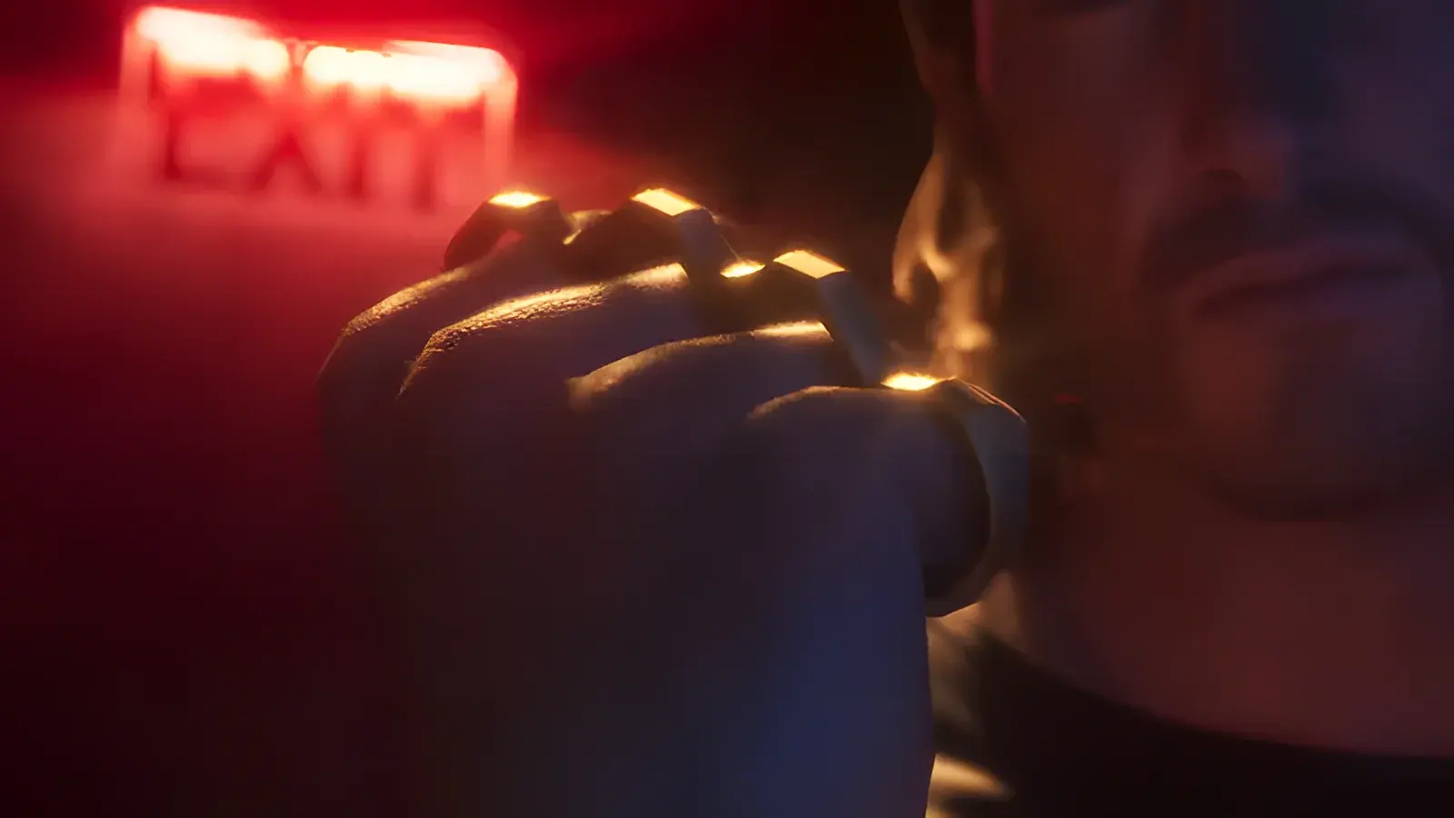 Knuckle Dusters in GTA 6, basata sull’arma reale Brass Knuckles. Pugno chiuso con un tirapugni dorato sotto un’insegna rossa di uscita, fotogramma del trailer di lancio di GTA 6