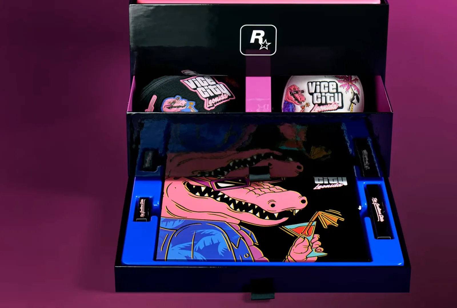 Rockstar render of the open GTA 6 collector’s edition box: Rockstar logo divider, two Vice City Leonida items on the middle level, pull-out tray with Macca the Gator art