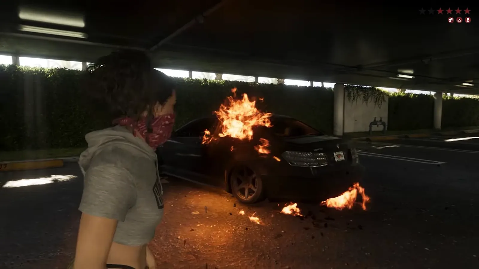 Lucia in a red bandana mask beside a burning black sedan in a parking garage with four red wanted stars and three icons at the top right of the GTA 6 HUD