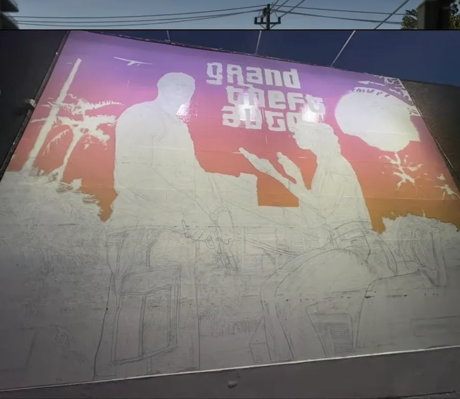 GTA VI mural being painted on a building wall in Brooklyn with sketch outlines still visible, a GTA 6 ad