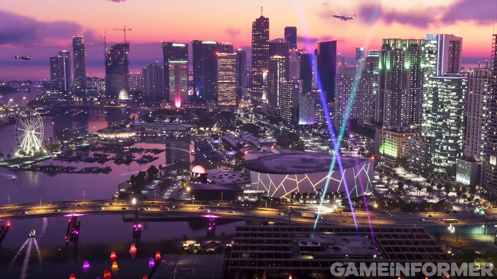Vice City skyline at dusk with a lit Ferris wheel, a marina and an arena lettered sahara arena under crossing light beams in GTA 6